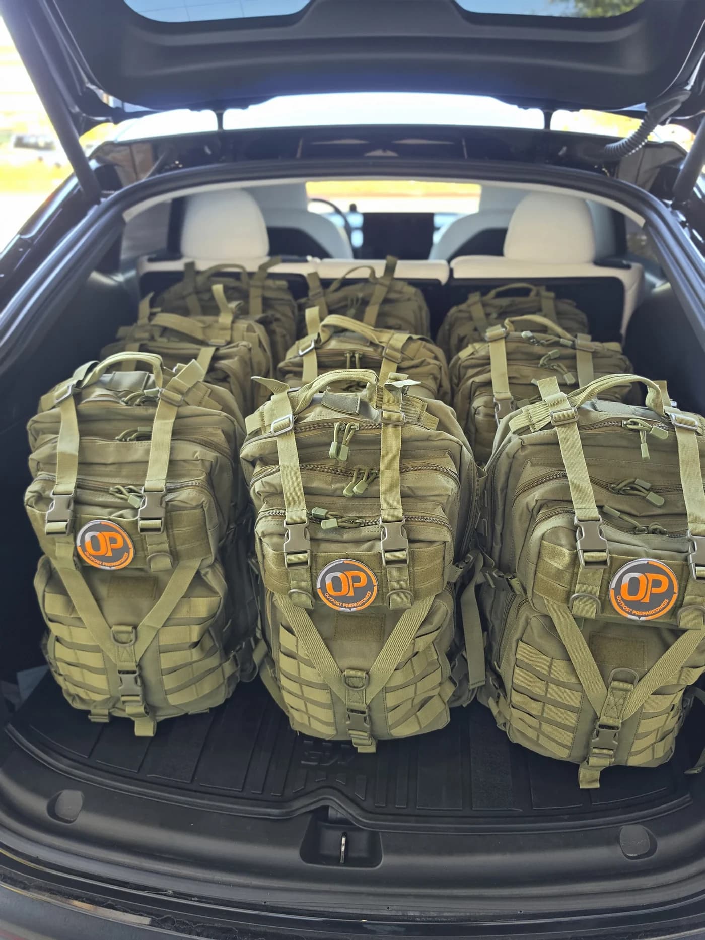 Packed Outpost go-bags loaded upright in the boot of a vehicle, ready to travel
