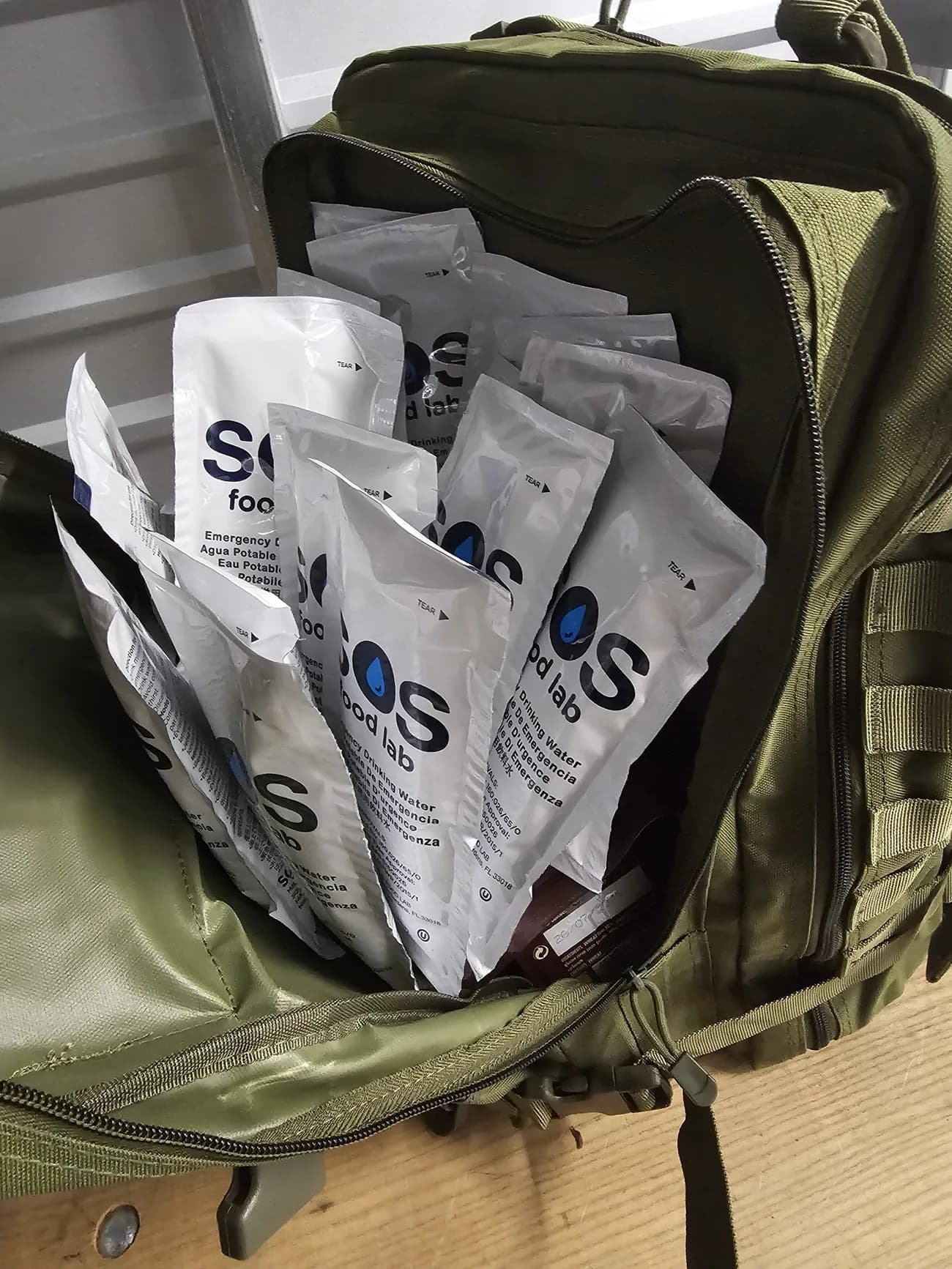 Emergency water pouches being packed into a go-bag