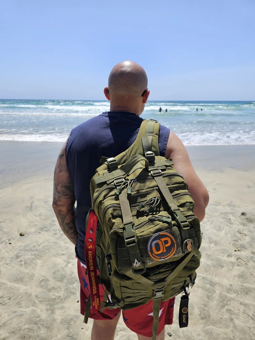 Drew Jennings carrying an Outpost go-bag on a beach